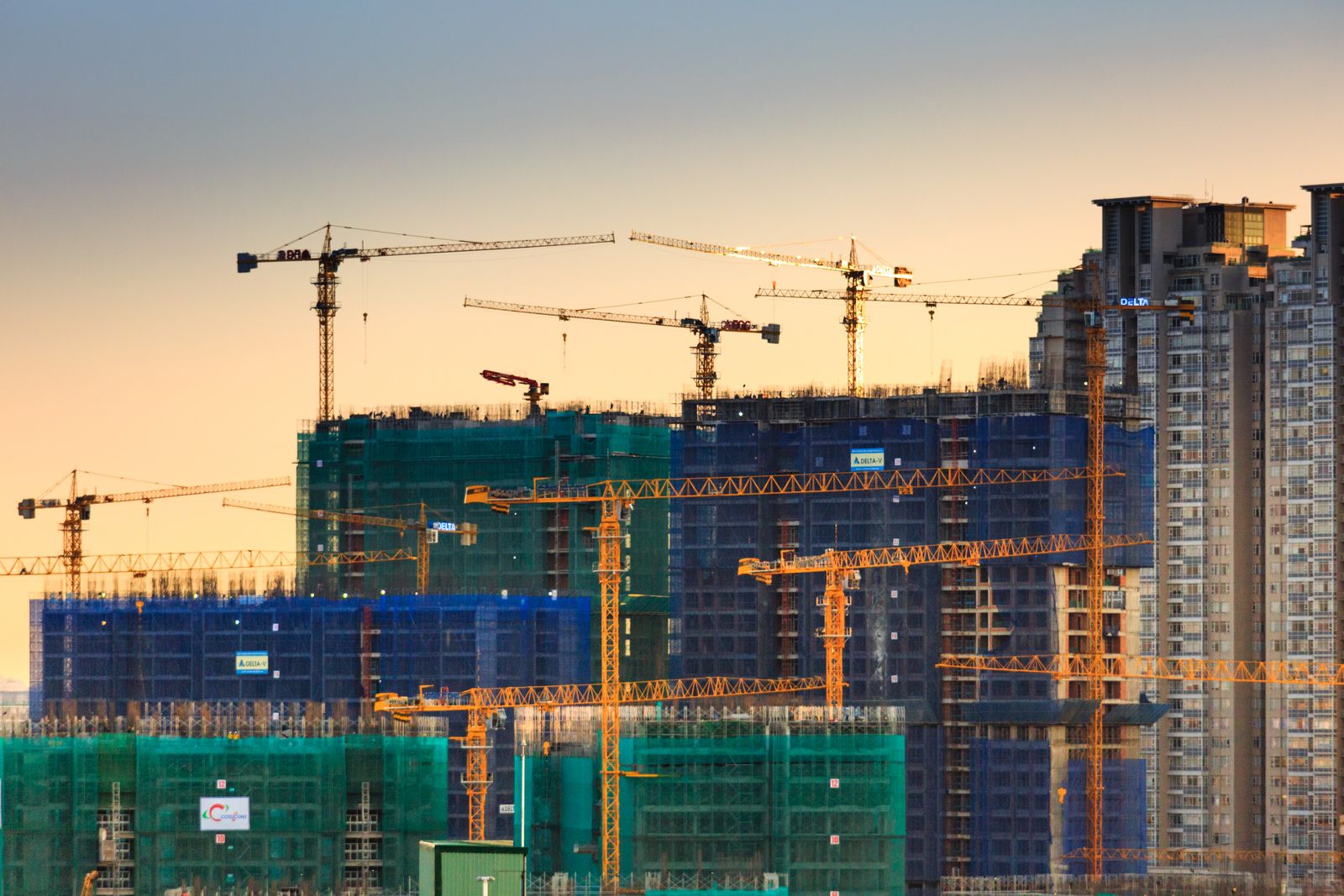 Construction cranes above residential towers in development